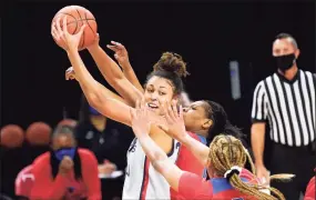  ?? Charles Rex Arbogast / Associated Press ?? UConn’s Olivia Nelson-Ododa is pressured by DePaul’s Deja Church (3) and Darrione Rogers during Sunday’s game in Chicago.