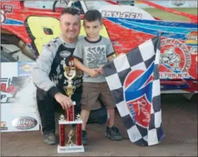  ?? Submitted Photo by DC/ Derak Covey ?? Modified feature winner Todd Burley and his son share a moment on Fathers Day at Utica- Rome Speedway Sunday in Vernon. It was Burley’s 30th career win at the track.