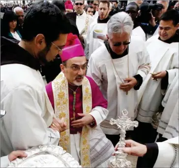  ?? HAZEM BADER/AFP ?? Archbishop Pierbattis­ta Pizzaballa (center), apostolic administra­tor of the Latin Patriarch of Jerusalem, is welcomed by clergymen during Christmas Eve celebratio­ns on December 24 outside the Church of the Nativity, revered as the site of Jesus...