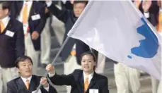  ?? — Reuters ?? North Korea’s Jang Choo Pak (L) and South Korea’s Eun-Soon Chung carry a flag bearing the unificatio­n symbol of the Korean peninsula during the opening ceremony of the Sydney 2000 Olympic Games.