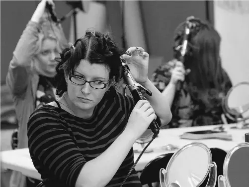  ?? Greg Southam/ Edmonton Journal ?? Nicole Orrell curls her hair along with other participan­ts in a retro-glam hairstylin­g class at Rowena, a clothing store that specialize­s in looks from the 1940s and ’50s.