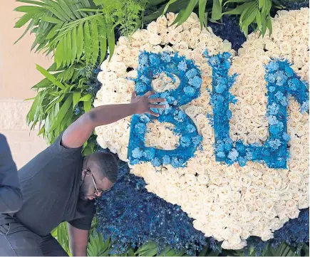  ?? Pictures: AP/PA. ?? Above: A Black Lives Matter floral tribute is delivered to a public memorial for George Floyd at the Fountain of Praise Church in Houston yesterday. Above right: A worker cleans graffiti from the plinth of the statue of Sir Winston Churchill in Parliament Square, London, following weekend protests.