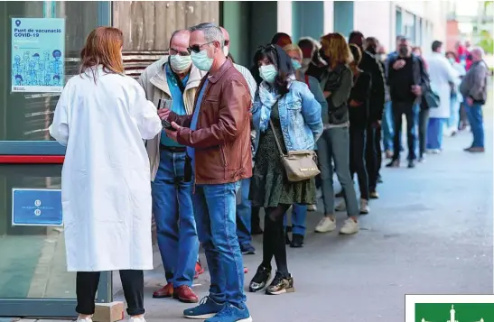  ?? EFE ?? Varias personas hacen cola en el centro de vacunación UB Raval de Barcelona, donde ya se vacunó un millón de personas