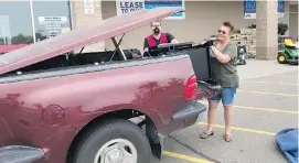  ?? PHOEBE WALL HOWARD, DETROIT FREE PRESS ?? Stephanie McRae loads up her husband’s 1997 Ford F-150: Pickup tops the truck shoppers’ list by a wide margin.