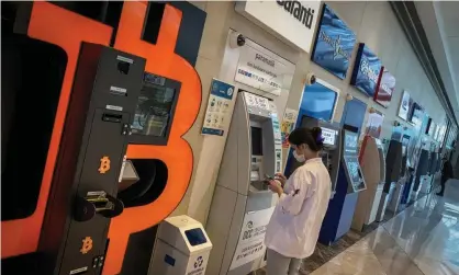  ?? Photograph: Chris McGrath/Getty Images ?? A woman uses a bank ATM next to a Bitcoin ATM machine at a shopping mall in Istanbul. Turkey’s central bank banned the use of cryptocurr­encies and crypto assets for purchases, citing the risks of possible huge losses.