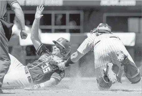  ?? Matt Miller Associated Press ?? FLORIDA STATE’S Cal Raleigh, left, is safe at home after avoiding the tag by Cal State Fullerton catcher Chris Hudgins in fourth inning.