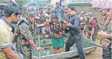  ?? — Reuters photo ?? Indian Army soldiers rescue people from flood affected areas.