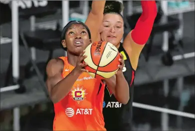  ?? MIKE CARLSON/AP PHOTO ?? Kaila Charles of the Connecticu­t Sun, left, shoots as Kayla McBride of the Las Vegas Aces defends during the first half of Thursday night’s WNBA game in Bradenton, Fla.