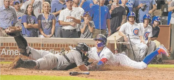  ?? | DAVID BANKS/ AP ?? Pirates catcher Francisco Cervelli ( left) tags out Cubs baserunner Javy Baez at the plate on the back end of a double play in the 10th inning Monday atWrigley Field. A replay review upheld the call.