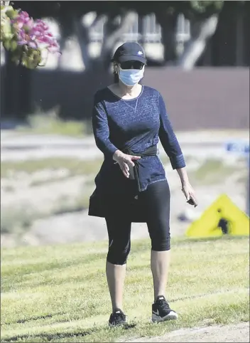  ??  ?? A MASKED WALKER makes her way around Ray Smucker Memorial Park on June 3.