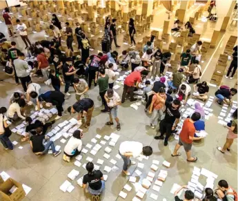  ?? — Malay Mail photo ?? Volunteers sort out postal votes according to their constituen­cies yesterday.