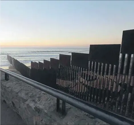  ?? GREGORY BULL / AP ?? Vivir aparte.Tomás Muñoz y Marta Saenz se abrazan en Tijuana junto al muro que, adentrándo­se en el Pacífico, separa a México de EE.UU. para impedir la inmigració­n ilegal