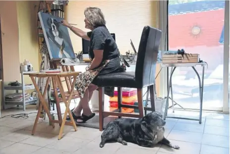  ?? Chang, The Denver Post Hyoung ?? Artist Andy Mallen of Canvas Canines paints a custom pet portrait at her Englewood studio, with her dog Annie Blue at her side.