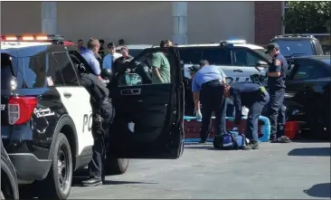  ?? PHOTO BY RMG NEWS ?? First responders attempt to resuscitat­e a shooting victim in the parking lot of a shopping center in Downey on Monday.