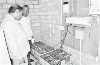  ?? (OPM photo) ?? Prime Minister Moses Nagamootoo (left) and Radio Paiwomak Coordinato­r Virgil Harding inspecting the batteries donated by OPM.