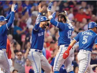  ?? MICHAEL DWYER/ASSOCIATED PRESS ?? The Toronto Blue Jays’ Raimel Tapia (15) celebrates his inside-the-park grand slam that scored teammates Lourdes Gurriel Jr., center left, Danny Jansen, left, and Santiago Espinal (5) during the third inning of Friday’s game against the host Boston Red Sox in Boston.