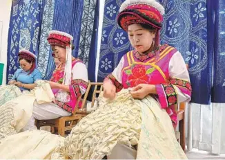  ?? WANG JING / CHINA DAILY ?? Women tie-dye fabric in Hequn village, Zhangjiaji­e, Hunan province.