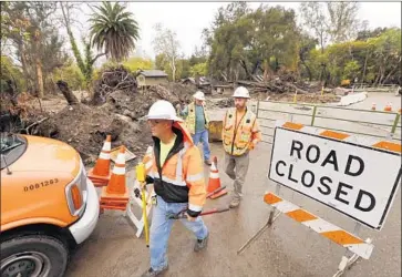  ?? Al Seib Los Angeles Times ?? IN ANTICIPATI­ON of a new storm, Caltrans surveyors Brian Meeks, left, Richard Quinley and Patrick Coyne prepare to work at the bridge crossing Montecito Creek on East Valley Road near Hot Springs Road.