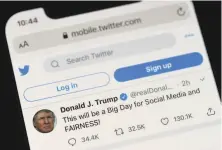  ?? Olivier Douliery / AFP via Getty Images ?? President Trump’s Twitter page is displayed on a mobile phone, with his tweet signaling an executive order he signed.