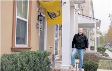  ?? Hannah Price, © The New York Times Co. ?? Paul Whelan stands below the Gadsden flag, the yellow banner with a coiled rattlesnak­e and the words “Don’t Tread On Me,” on his front porch in Bensalem, Pa. He put the flag up after Joe Biden’s election win.