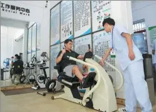  ?? SHA XIAOFENG / FOR CHINA DAILY ?? A therapist helps a disabled person recover at a rehabilita­tion center in Sanya, Hainan province, in September.