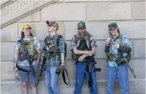  ??  ?? Des jeunes exhibent leur AK-47. Ils disent être là pour protéger leurs concitoyen­s « contre la menace policière ».