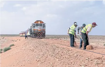  ??  ?? TRAINING SIGHTS: Workers clearing sand from the train tracks of the Oriental Desert Express. The 350-kilometre journey takes between eight to 12 hours or more, depending on the sandstorms.