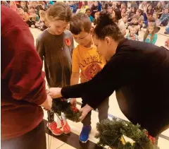  ?? photo : Gracieuset­é École La Source ?? Harvey Reichert et Rowan Taggard, élèves de 2e année à l’école La Source, déposent des couronnes de coquelicot­s.