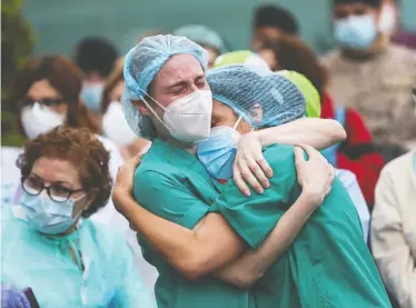  ?? SUSANA VERA/REUTERS ?? Health workers react during a tribute for their co-worker Esteban, a male nurse who died from the COVID-19 outbreak, outside the Severo Ochoa Hospital in Leganes, Spain, on Monday.