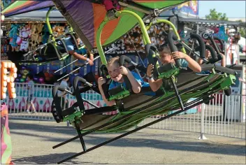  ?? CARIN DORGHALLI — ENTERPRISE-RECORD FILE ?? Mason Ellgood and Leonardo Villicana fly through the air on a carnival ride at the Glenn County Fair on May 18, 2018.