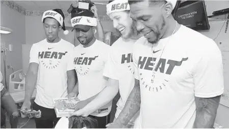  ?? MIAMI HEAT ?? From left, Josh Richardson, Dwyane Wade, Kelly Olynyk and Udonis Haslem were among Heat players who attempted to spread holiday cheer at children’s hospitals over the last week.