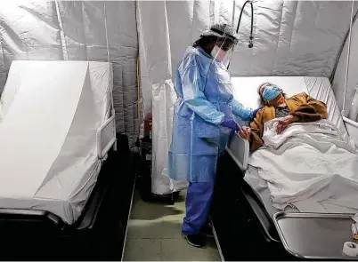  ?? Photos by Bob Owen / Staff photograph­er ?? Nurse Jave Blackburn comforts COVID-19 patient Alma Stokes in the infusion tent unit at Coventry Hospital in Lubbock.