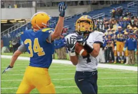  ?? DAVID TURBEN — THE NEWS-HERALD ?? Kirtland’s Joey Torok catches a TD pass past John Tangeman on Dec. 2 during the Hornets’ loss to Marion Local in the Division VI state championsh­ip game in Canton.