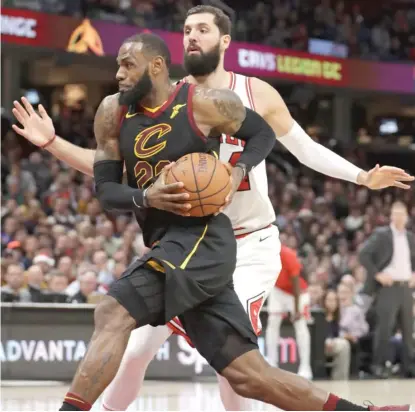  ?? | TONY DEJAK/ AP ?? LeBron James, who had a game- high 34 points, drives past Bulls forward Nikola Mirotic in the first half Thursday.