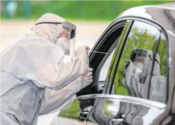  ?? FOTO: JOHN MACDOUGALL/AFP ?? Ein Arzt in Schutzklei­dung an einer Coronaviru­s-Teststatio­n in Berlin.