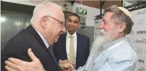  ?? (Mark Neyman/GPO) ?? PRESIDENT REUVEN RIVLIN embraces former MK Ya’acov Katz (Katzele) at the Jerusalem Conference organized by Besheva, while Besheva chairman Dudu Saada looks on.