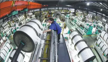  ?? GENG YUHE / FOR CHINA DAILY ?? An employee works on the production line of a textile company in Lianyungan­g, Jiangsu province.