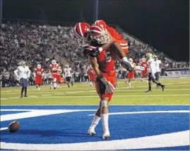  ?? Gina Ferazzi Los Angeles Times ?? MATER DEI’S CJ Parks leaps on fellow wide receiver Bru McCoy on Saturday after McCoy’s fourth-quarter touchdown against St. John Bosco.