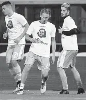  ?? Gianni Schicchi AFP/Getty Images ?? ITALY’S Lazio team players wear shirts bearing Anne Frank’s image before a match against Bologna.