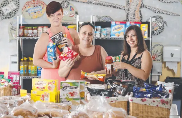  ?? Picture: ANNA ROGERS ?? TOP TUCKER: Bonnie Falkiner and Suzanne Hinks with support worker Helen Payet at Anglicare's pop-up shop at Marlin Coast Neighbourh­ood Centre.