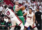  ?? WILFREDO LEE / AP ?? Miami Heat center Bam Adebayo (13) and guard Kyle Lowry (7) defend Boston Celtics center Al Horford (42).