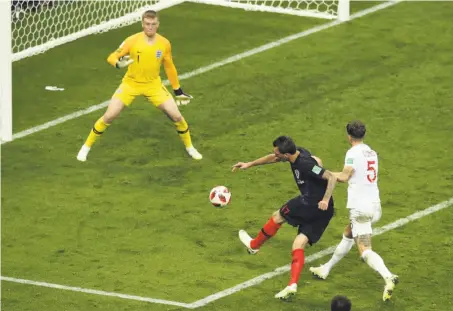  ?? Thanassis Stavrakis / Associated Press ?? Mario Mandzukic scores Croatia’s game-winning goal past England keeper Jordan Pickford in the 109th minute.