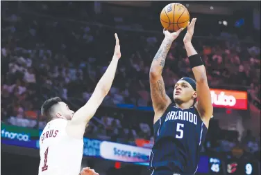  ?? Associated Press ?? Taking aim: Orlando Magic forward Paolo Banchero (5) shoots against Cleveland Cavaliers guard Max Strus (1) during the second half of Game 2 of an NBA basketball first-round playoff series Monday in Cleveland.