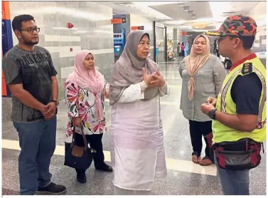  ??  ?? Solemn talk: Zuraida (centre) speaking with Kuala Lumpur Fire Enforcemen­t officer Muhamad Hafidz Yaacob after visiting Muhammad Adib at IJN in Kuala Lumpur.