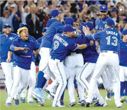  ?? | AP ?? The Blue Jays celebrate after reaching the AL Championsh­ip Series for the first time since 1993 by defeating the Rangers.