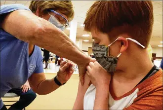  ?? BILL LACKEY / STAFF ?? Piper Atkinson, 16, gets her first COVID vaccine injection Tuesday at the Clark County vaccine distributi­on center at the Upper Vally Mall.