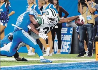  ?? RICK OSENTOSKI THE ASSOCIATED PRESS ?? New York Jets wide receiver Quincy Enunwa (81) reaches to score on a 21-year touchdown reception as Lions defensive back Nevin Lawson defends in second-half National Football League action in Detroit on Monday night. The Jets smoked the Lions, 48-17. For complete coverage, visit thespec.com.