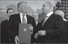  ?? [SUSAN WALSH/THE ASSOCIATED PRESS] ?? President Donald Trump smiles at Israeli Prime Minister Benjamin Netanyahu after signing a proclamati­on formally recognizin­g Israel’s sovereignt­y over the Golan Heights. The leaders were in the Diplomatic Reception Room at the White House on Monday.