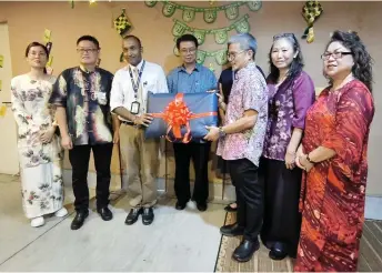  ?? — Photo by Peter Boon ?? Dr Annuar (third right) symbolical­ly hands over the contributi­ons to Dr Nanthakuma­r, witnessed by Lau (fourth left) and others.