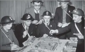  ?? PICTURES: REG SPELLER/ FOX PHOTOS/ GETTY IMAGES. ?? ON THE MARCH: Top, Hackney air raid wardens on the march during training in 1940 with dummy rifles, which were used to give a smart impression; above, wardens in the village of Harrow Weald, who built a model of their village for instructio­n purposes.